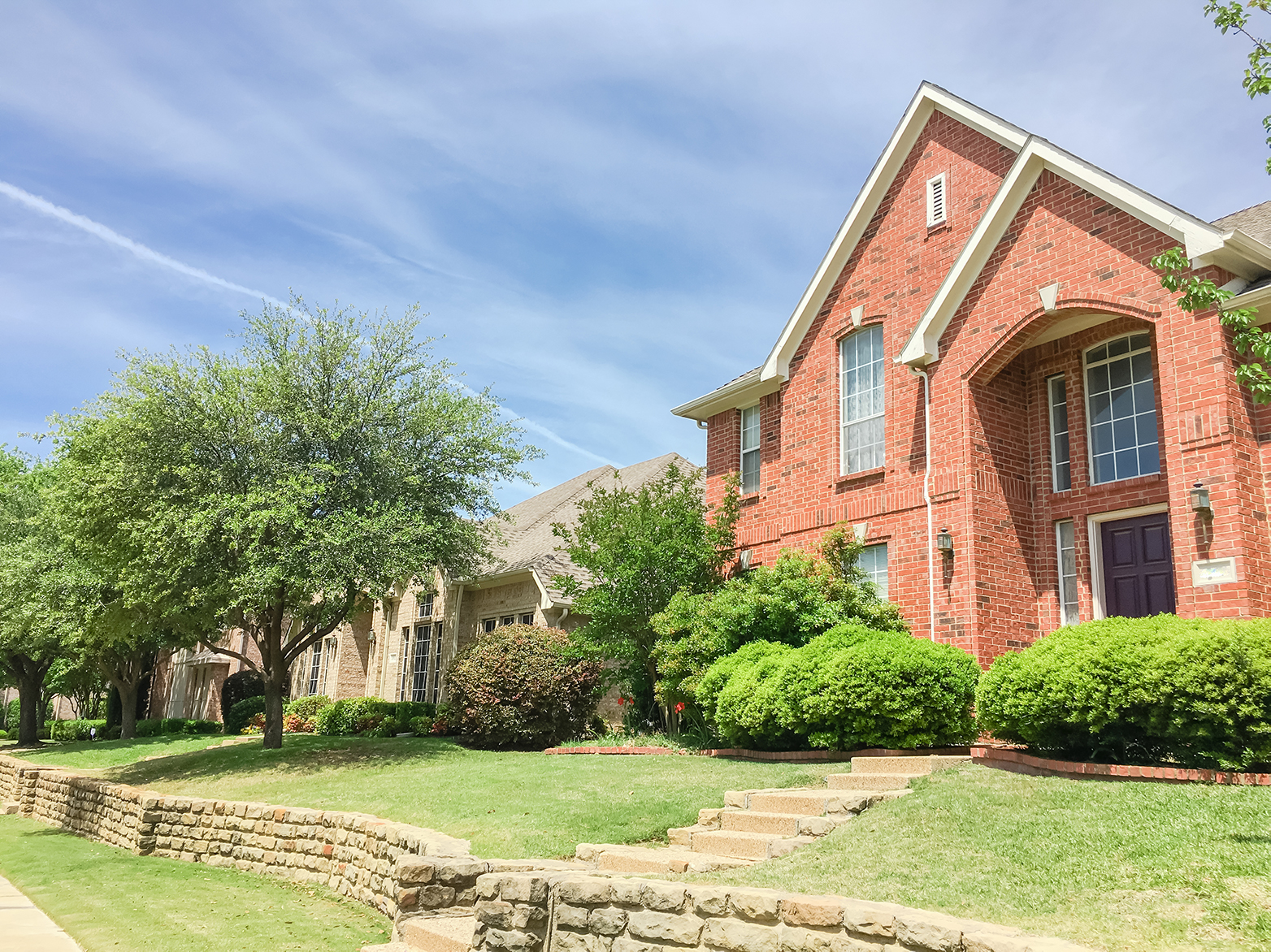 Brick home with stone and lush landscaping