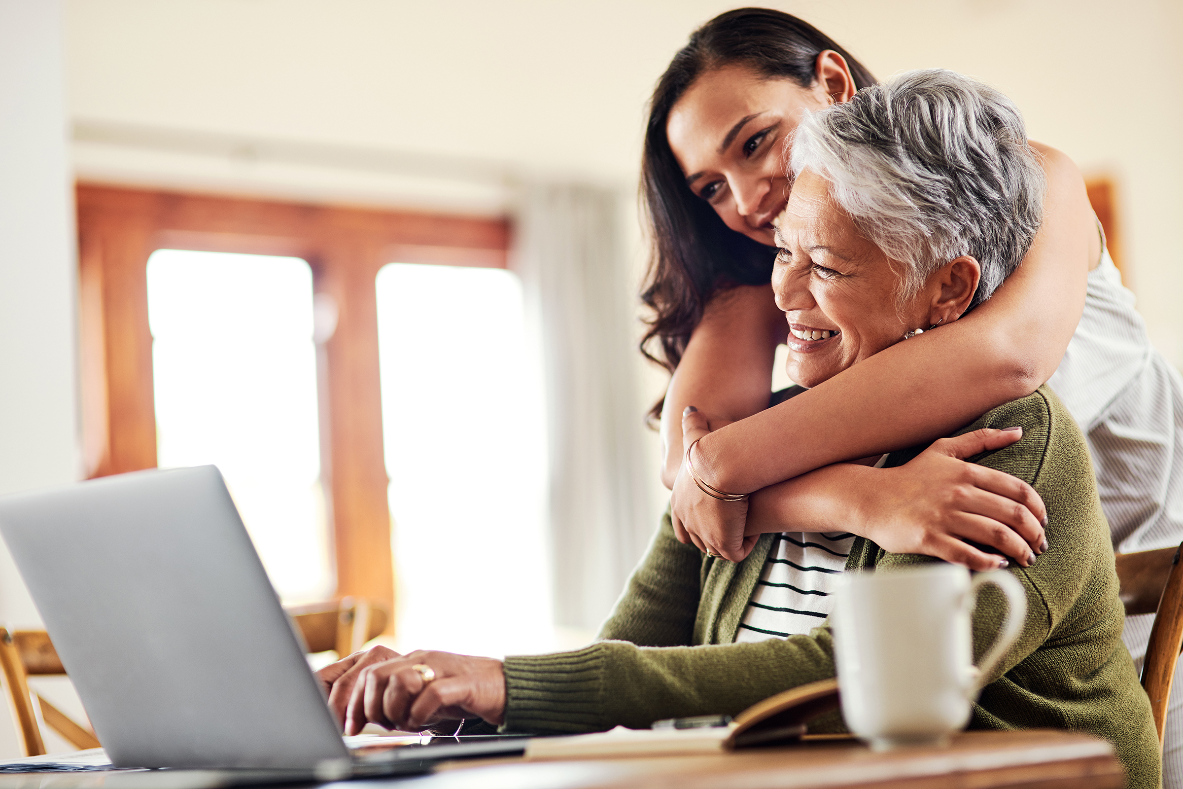 Happy mother and daughter with laptop computer