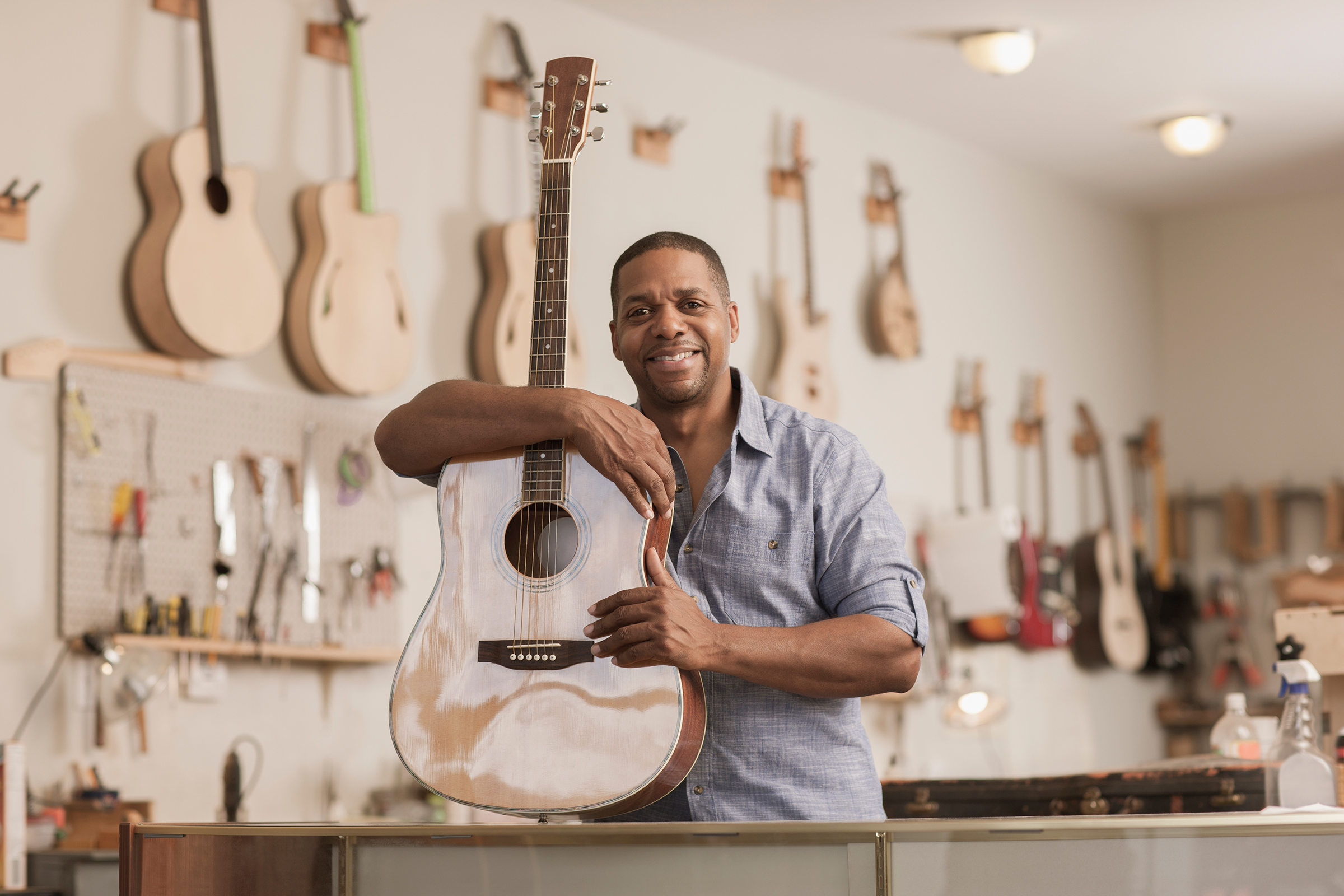 Man with guitar in guitar shop
