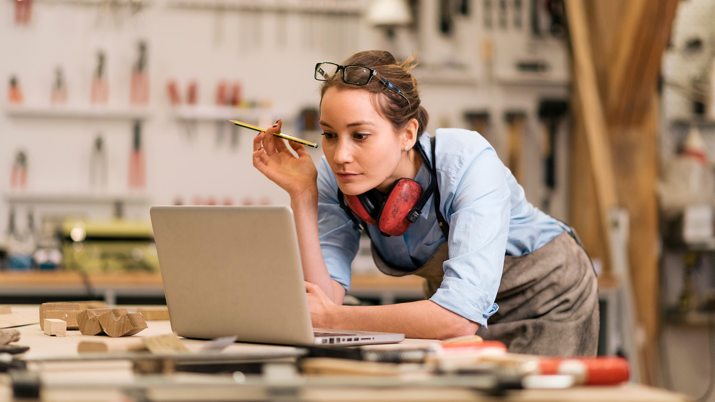 Craftswoman looking at laptop in workshop