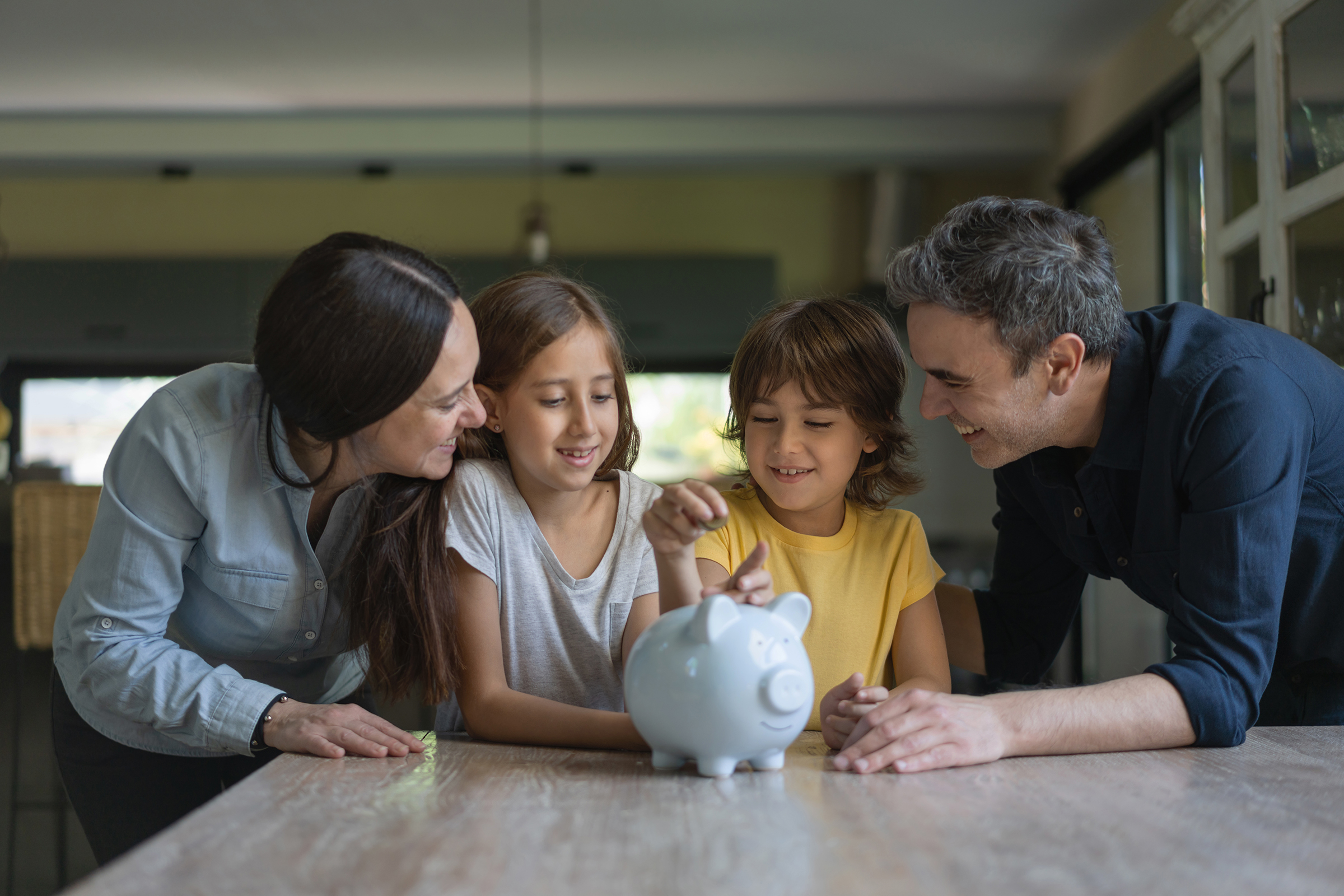 Family saving money in piggy bank