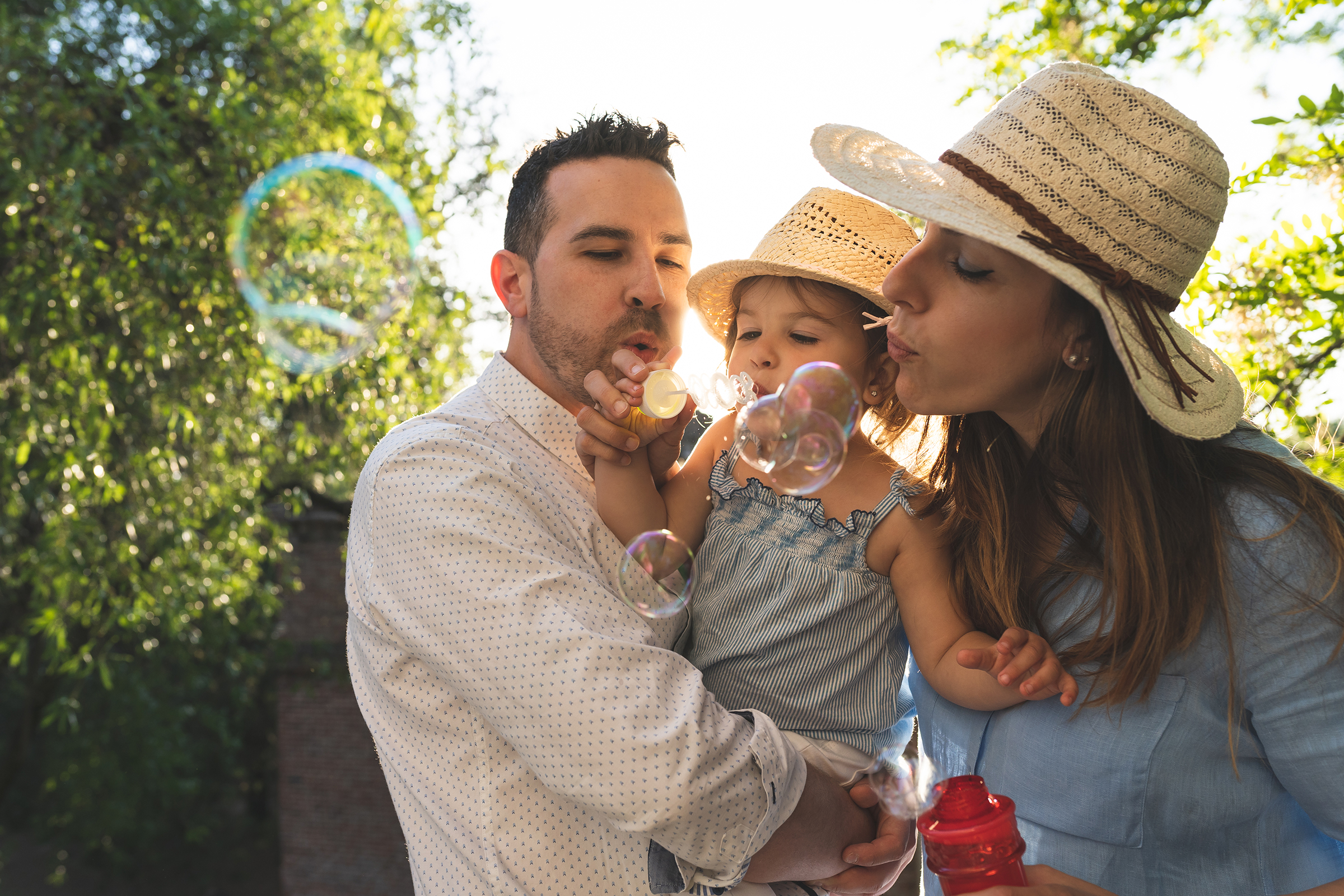 Family with child blowing bubbles outside