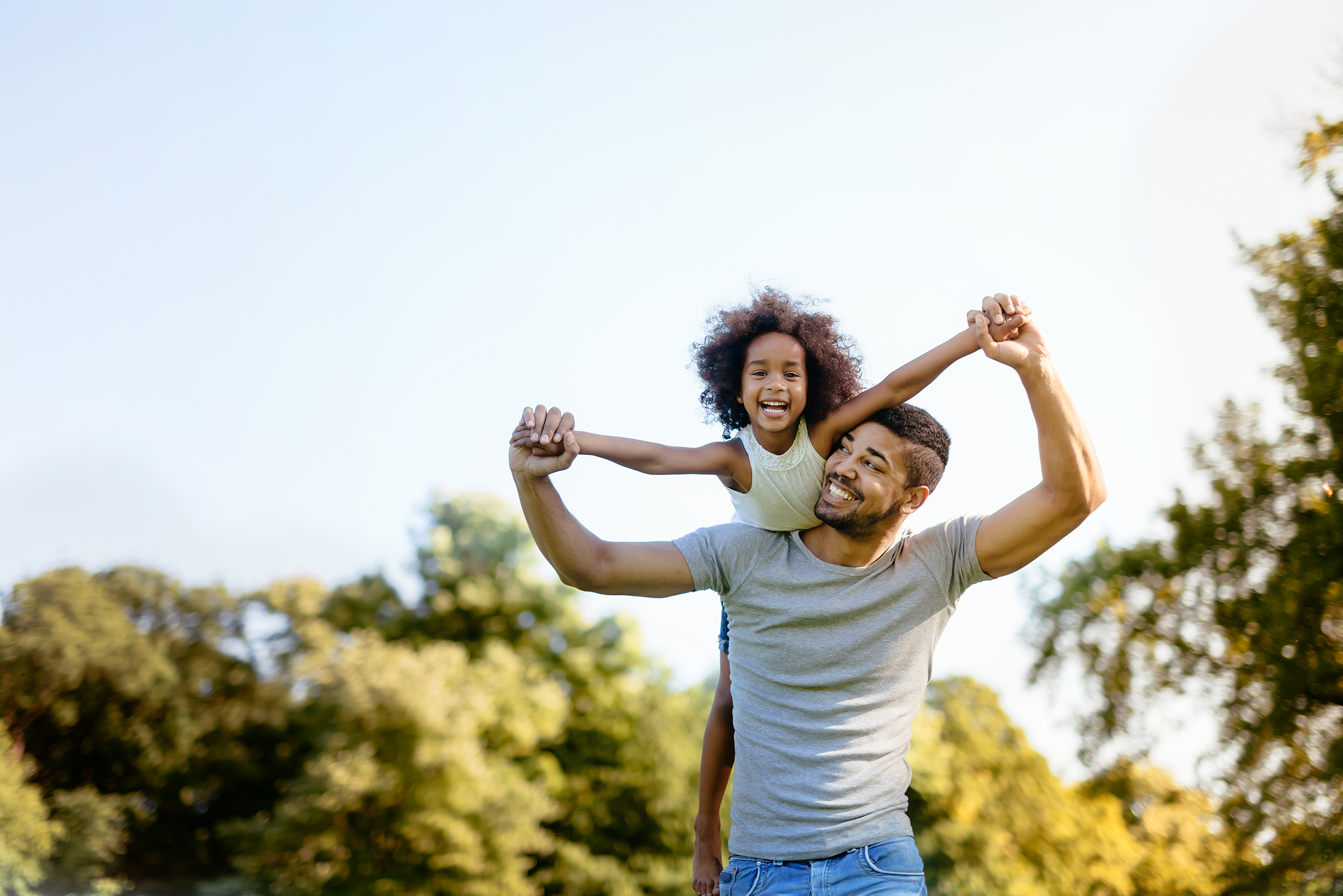 Father carrying daughter on back outdoors