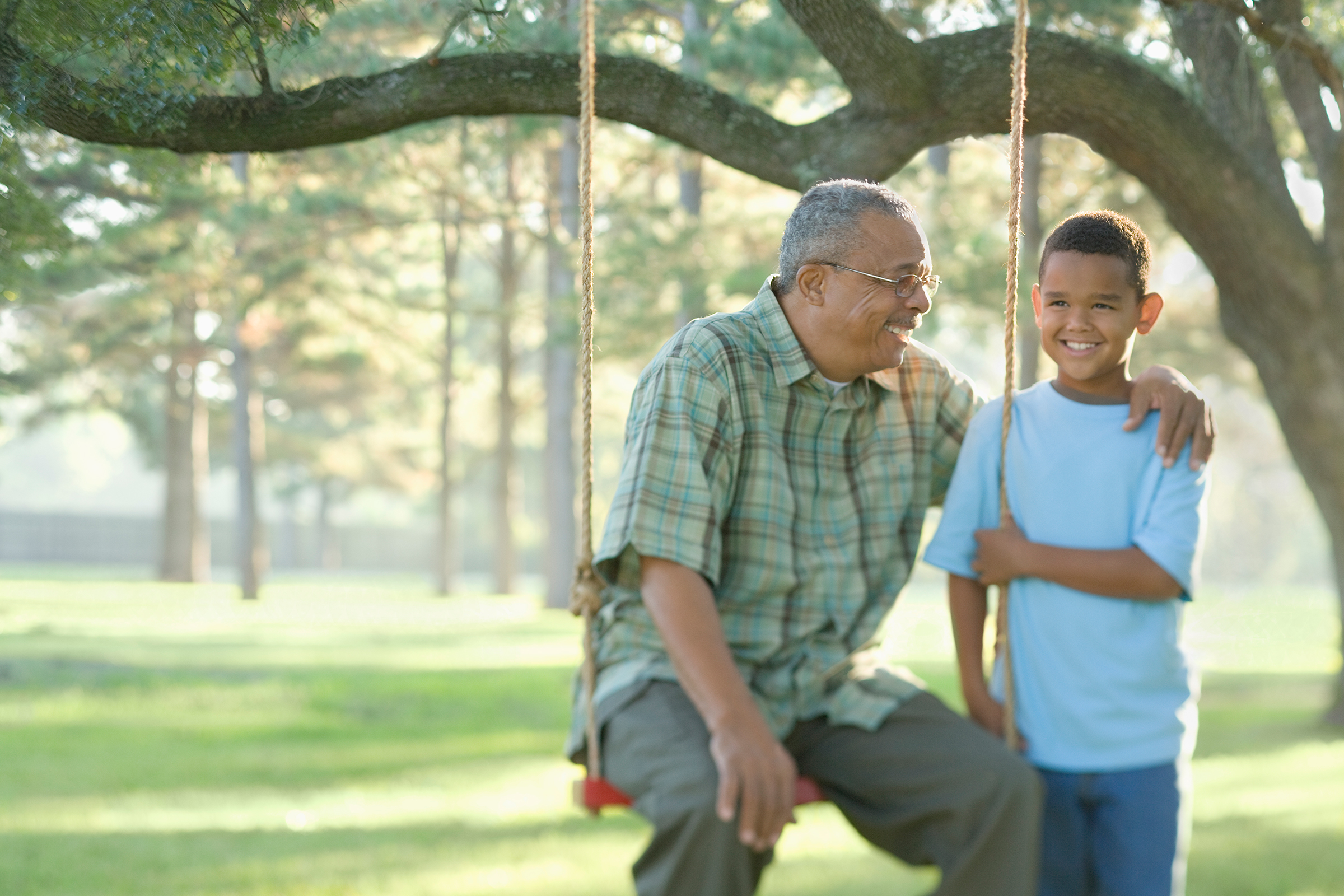 Grandfather on swing next to grandson
