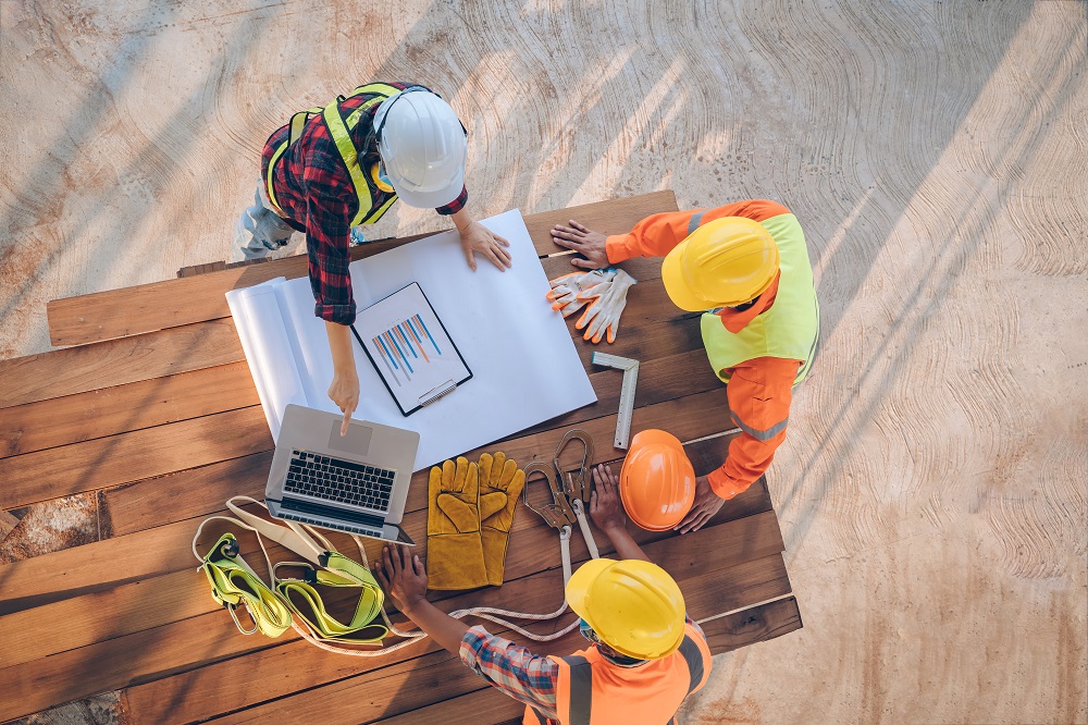 Group of construction workers around a table looking at plans
