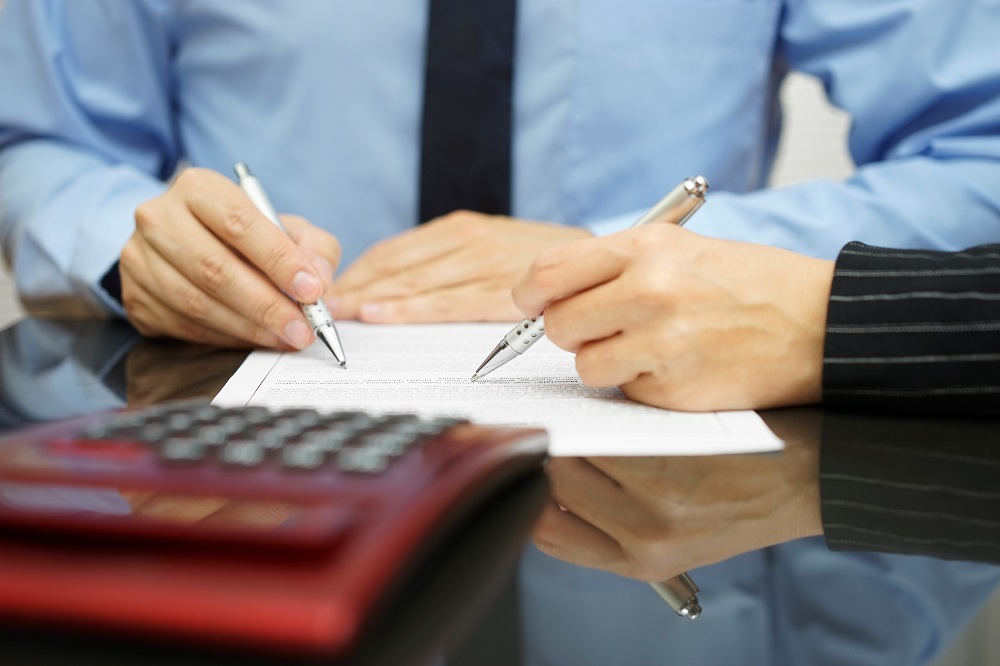 businessman and female coworker are examining financial agreement