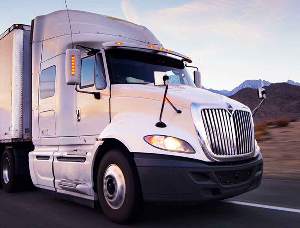 White 18 wheeler truck driving on highway