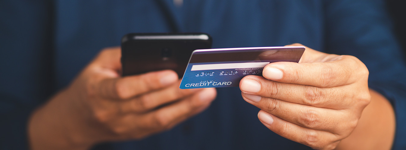 Person holding a credit card and phone